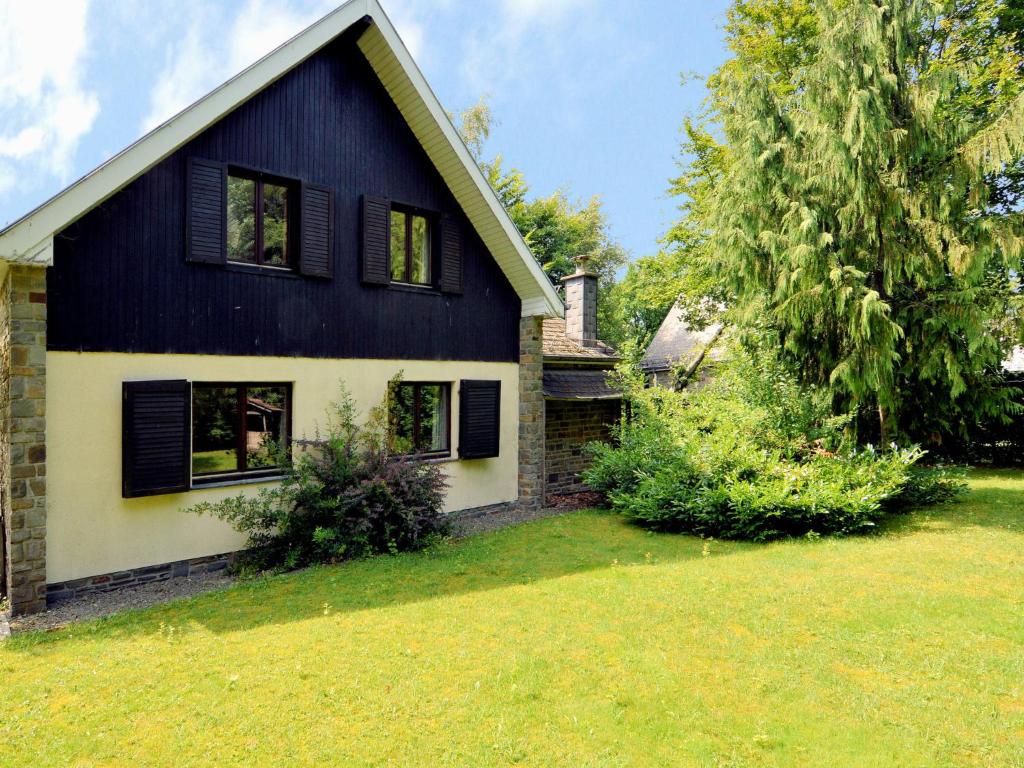 una casa en blanco y negro con un patio en Inviting chalet in the woods in Ovifat, en Waimes