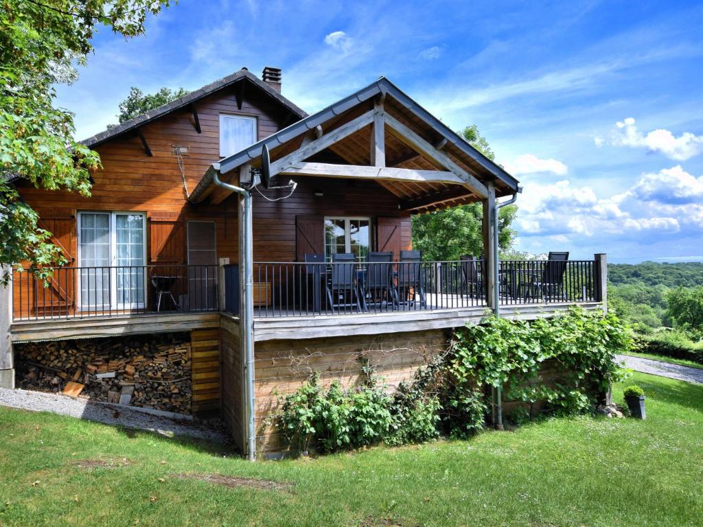 a house with a deck with chairs on it at Atmospheric chalet with sauna and jacuzzi in Septon