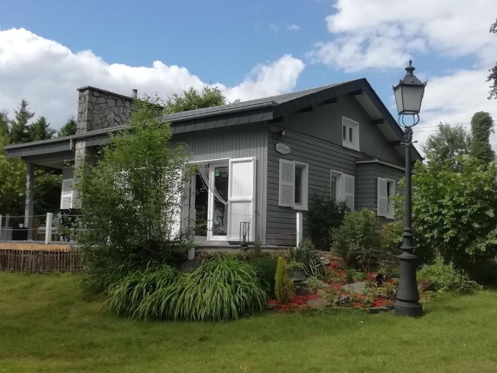 a gray house with a street light in front of it at Peaceful Chalet in Transinne with Patio in Libin