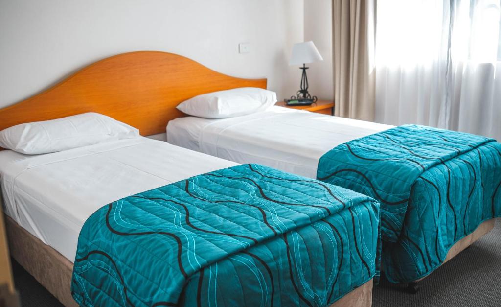 Postel nebo postele na pokoji v ubytování Heritage Cairns Hotel