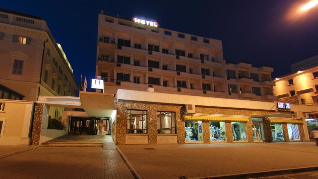 una calle vacía delante de un edificio por la noche en Hotel Mediterraneo, en Civitavecchia