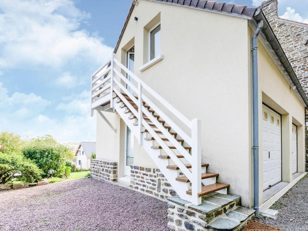 una casa con una escalera blanca junto a un garaje en Magnificent flat with garden in Saint R my, en Clécy