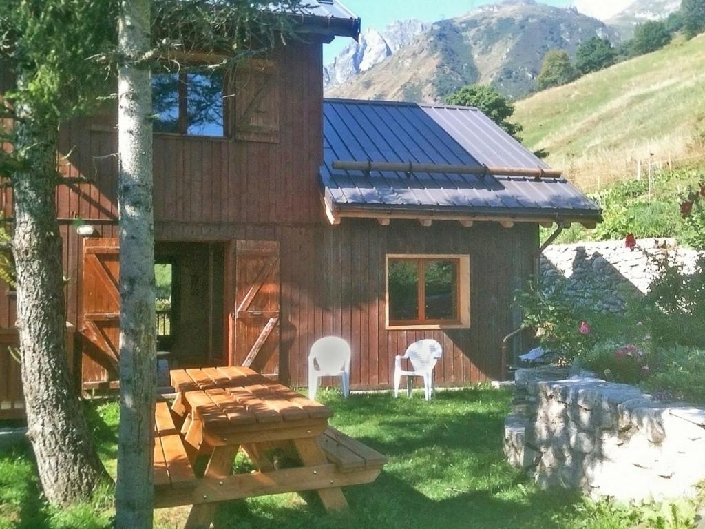 een huisje met een tafel en stoelen in de tuin bij The ideal chalet for a relaxing holiday in the mountains in Celliers