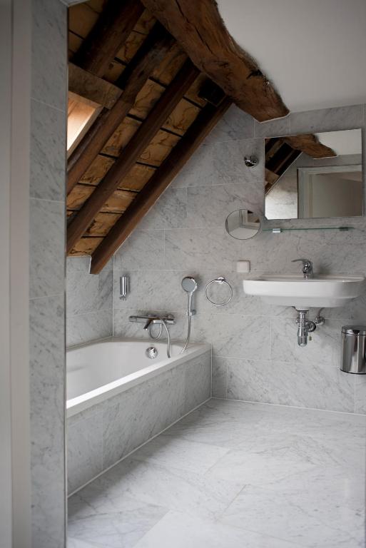 een badkamer met een ligbad en een wastafel bij Boutique hotel Sint Jacob in Maastricht