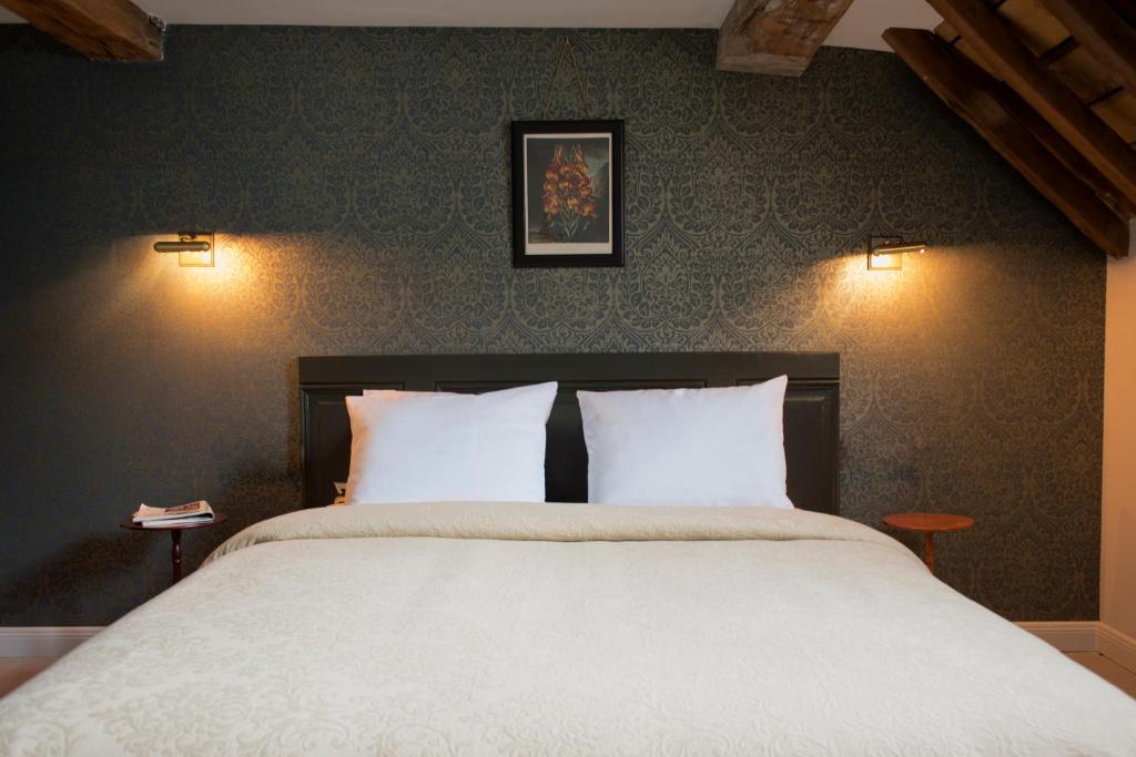 a bedroom with a large bed with two white pillows at Boutique hotel Sint Jacob in Maastricht