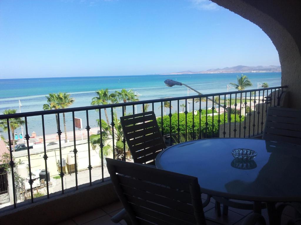 balcón con mesa y sillas y la playa en Las Gaviotas Condo-Hotel La Paz BCS, en La Paz