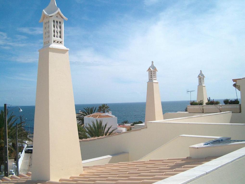 two white lighthouses on the roof of a building at Vilas do Mar in Carvoeiro
