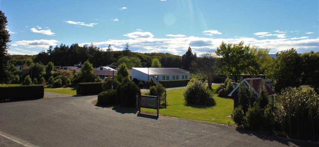 a driveway to a house with a sign in the yard at Last Light Lodge in Tuatapere