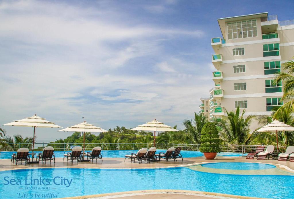 uma piscina num resort com cadeiras e guarda-sóis em Ocean Vista em Mui Ne