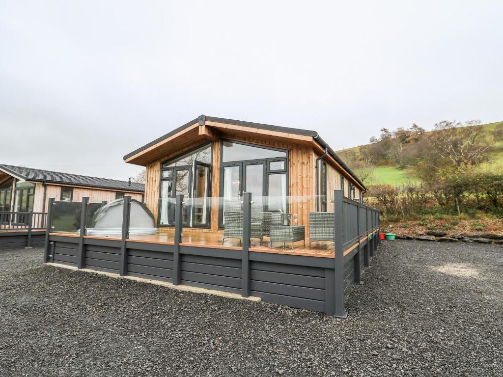 a house with a gazebo on a gravel lot at Sycamore Lodge in Llanidloes