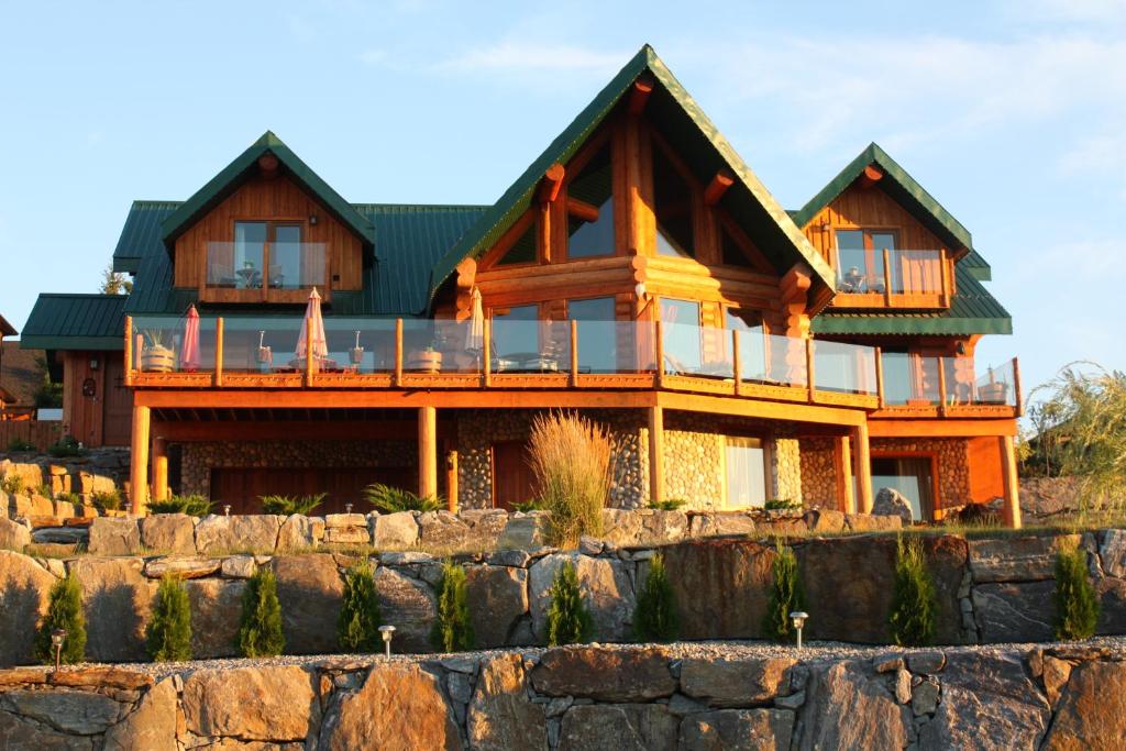 a large wooden house with a green roof at A Okanagan Lakeview Inn in Kelowna