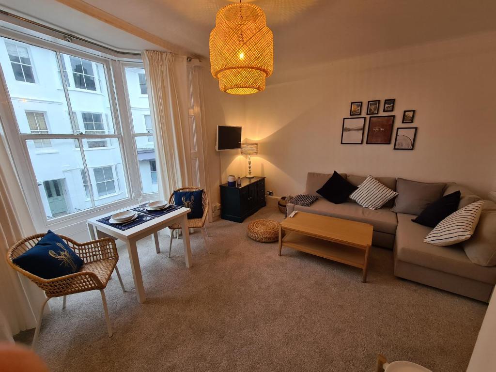 a living room with a couch and a table at Centrally located, comfortable apartment near Station, Beach and North Laines in Brighton & Hove