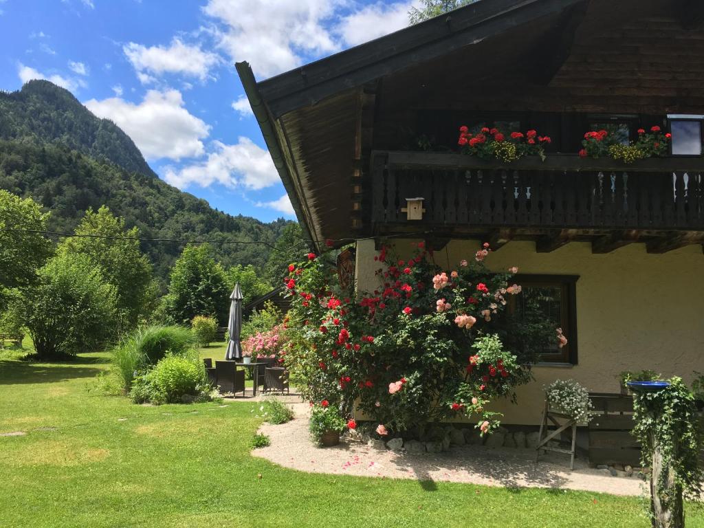 ein Gebäude mit einem Balkon mit Blumen darauf in der Unterkunft Am Schlierbach in Unterwössen