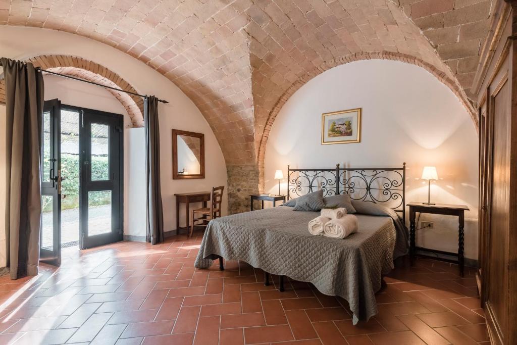 ein Schlafzimmer mit einem Bett in einem Zimmer mit einem Torbogen in der Unterkunft Agriturismo San Ottaviano in Monterotondo