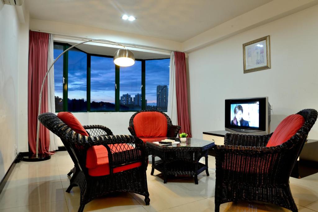 a living room with chairs and a table and a television at Likas Square - KK Spacious Homestay in Kota Kinabalu