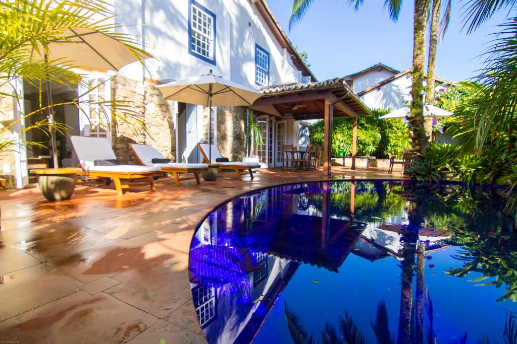 a house with a swimming pool in front of a house at Casa Simone Pousada in Paraty