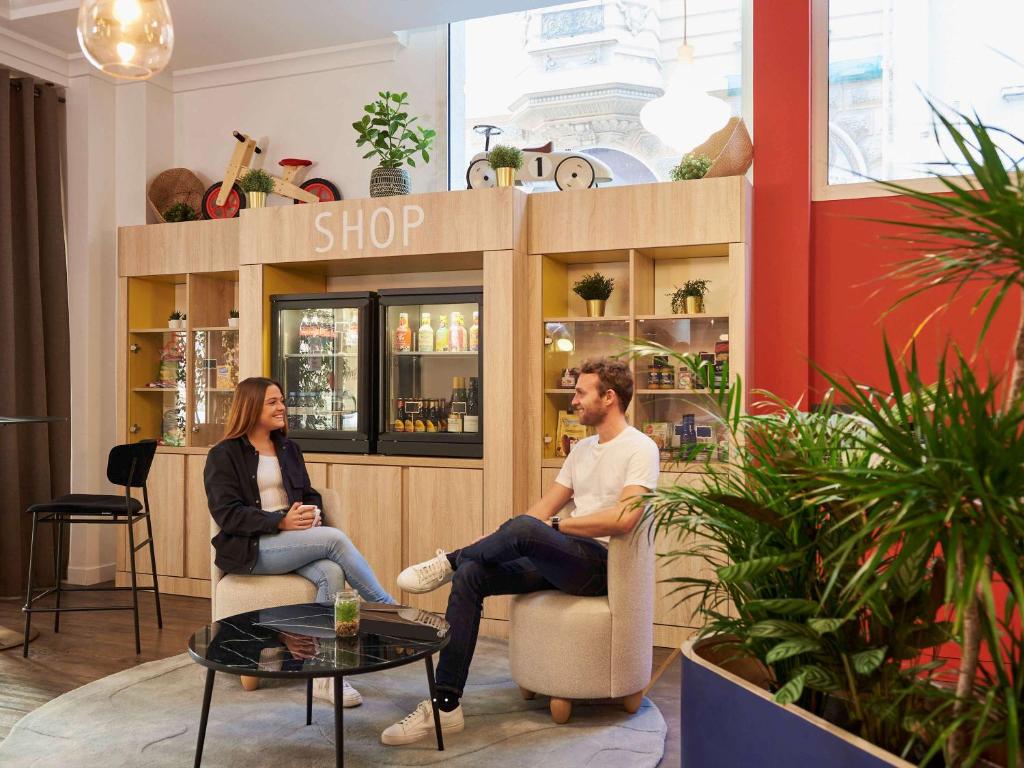 a man and woman sitting in chairs in a shop at Aparthotel Adagio Monaco Palais Joséphine in Beausoleil