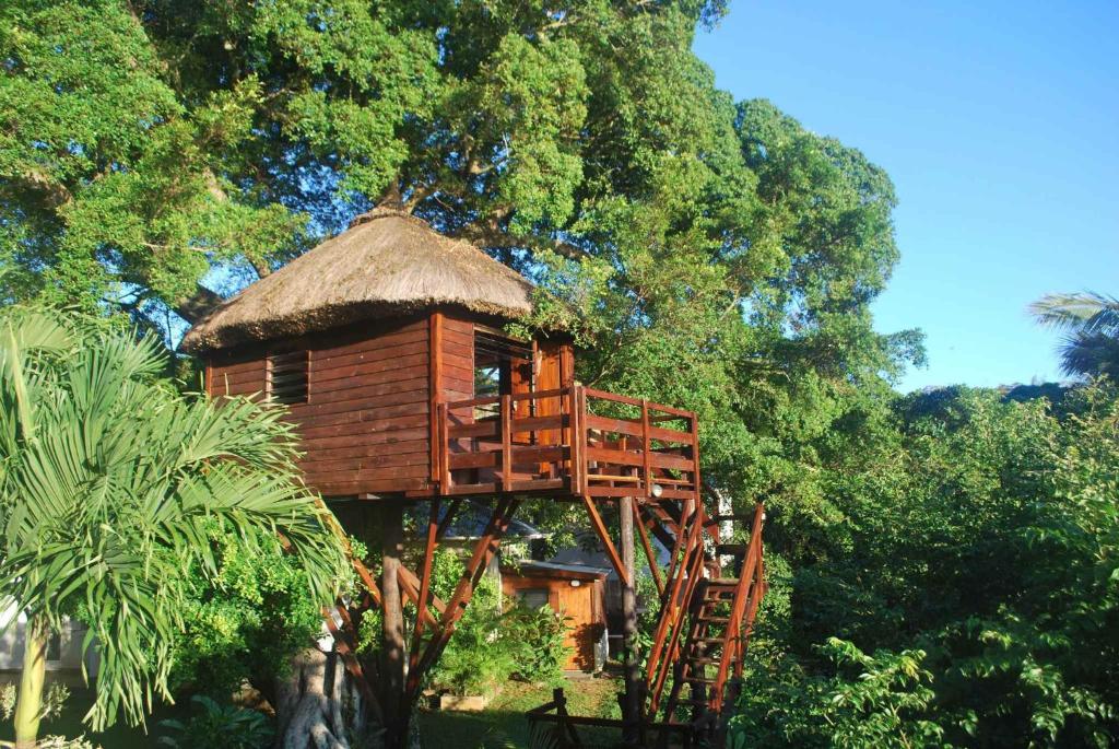 una casa en el árbol con techo de paja en Tree Lodge Mauritius en Belle Mare