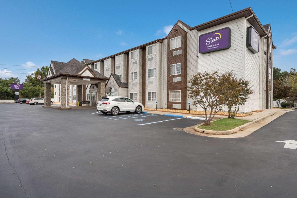 a building with a car parked in a parking lot at Sleep Inn & Suites in Decatur