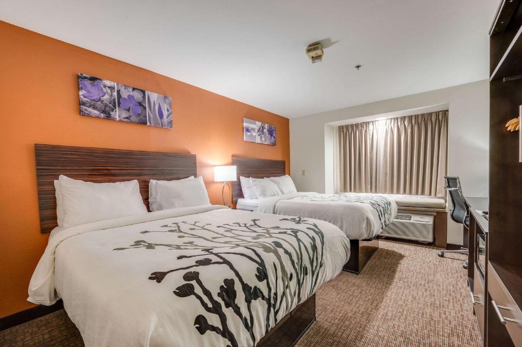 a hotel room with two beds and a television at Sleep Inn & Suites in Decatur