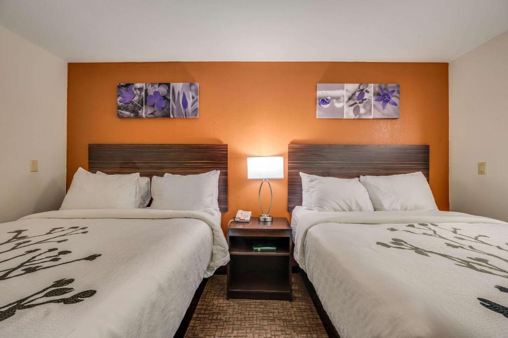 two beds sitting next to each other in a hotel room at Sleep Inn & Suites in Decatur