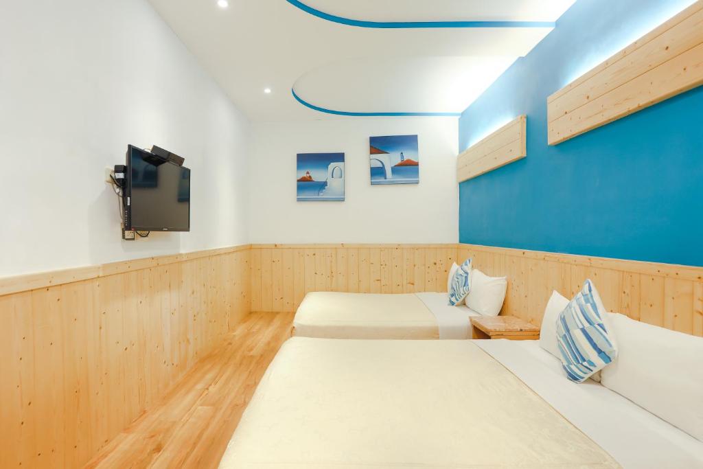 a room with two beds and a flat screen tv at Xing Ji Hotel in Kenting