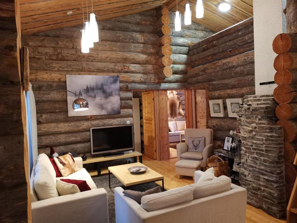 sala de estar con paredes de madera y TV en Villa Otsola in Ruka, en Ruka