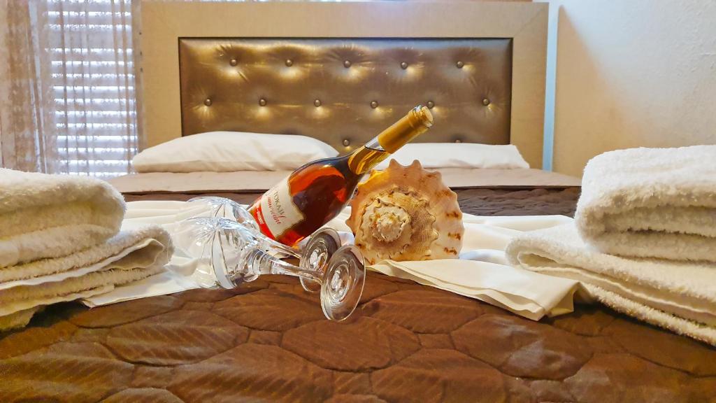 una bottiglia di champagne in cima a un letto di Villa Pirofani a Sárti