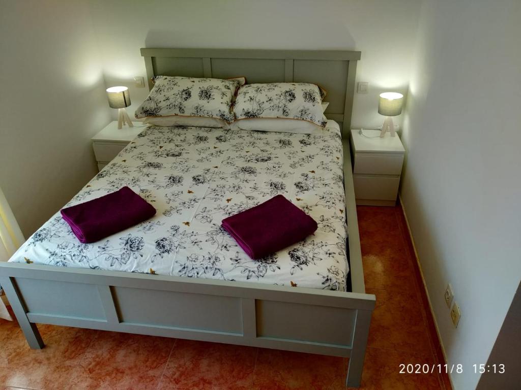 uma cama num quarto com duas almofadas em Casa Laura em Caleta de Fuste