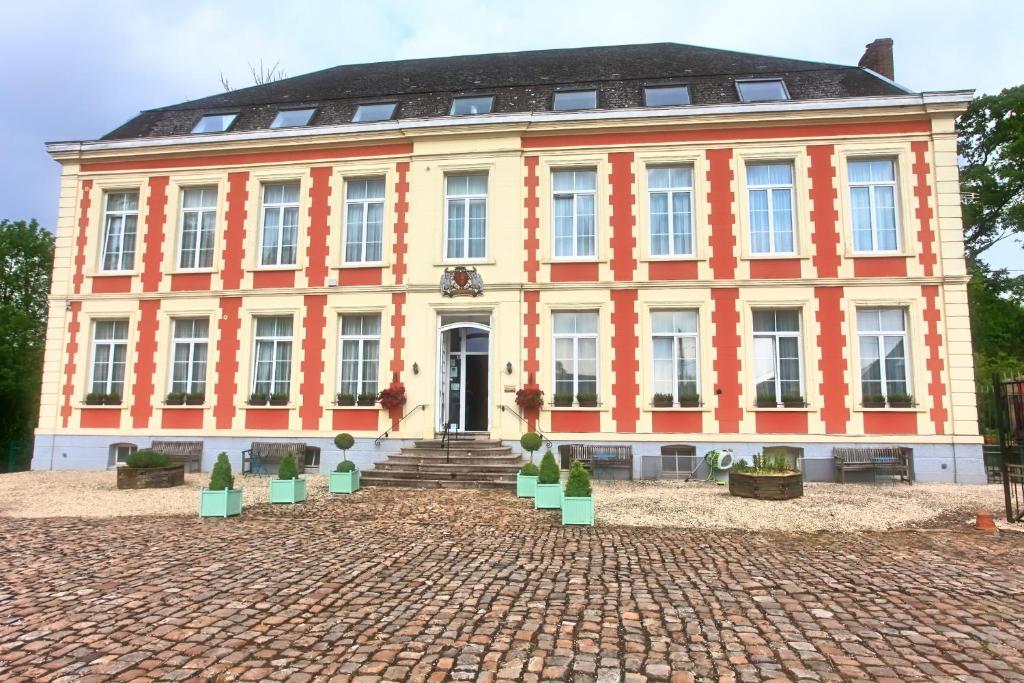 a large building with a clock on the front of it at Chateau de Moulin le Comte in Aire-sur-la-Lys