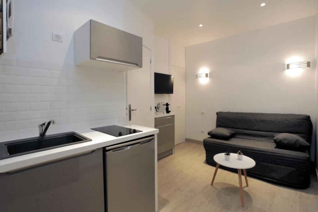 une cuisine avec un évier et un canapé dans une chambre dans l'établissement C005-Studette au centre Cannes, à Cannes