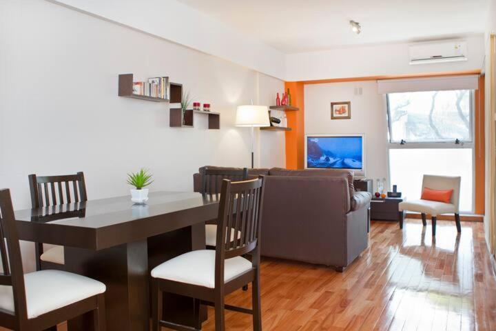 uma sala de estar com uma mesa e cadeiras e um sofá em Apartamento en Palermo em Buenos Aires