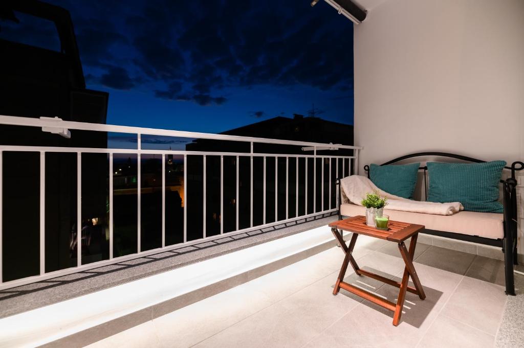 a balcony with a couch and a table at Kailani Luxury Central 3 Bedroom, 3 Bathroom Apartment With a Sunny Balcony in Zadar