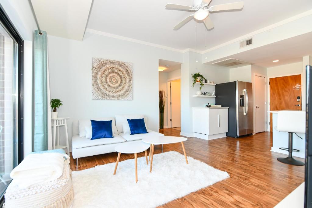 a living room with a white couch and blue pillows at {Cloud 9} Luxury 2 Bedroom Condo in Uptown Charlotte in Charlotte