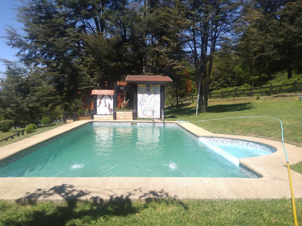 a swimming pool with a gazebo in a yard at Cabañas Wualmapu " acceso sólo vehiculos tipo camioneta, jeep o SUV" in Pucón