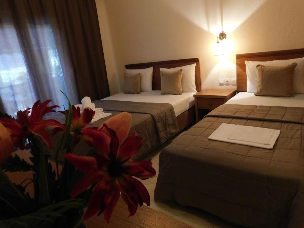 ein Hotelzimmer mit 2 Betten und einer Blume auf dem Boden in der Unterkunft Anna house 1 in Sarti