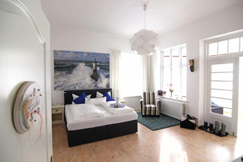 Kapitaenshaus-Lassen-Zimmer-Kapitaen-Blaubaer في فيسترلاند: غرفة نوم بها سرير ونافذة كبيرة