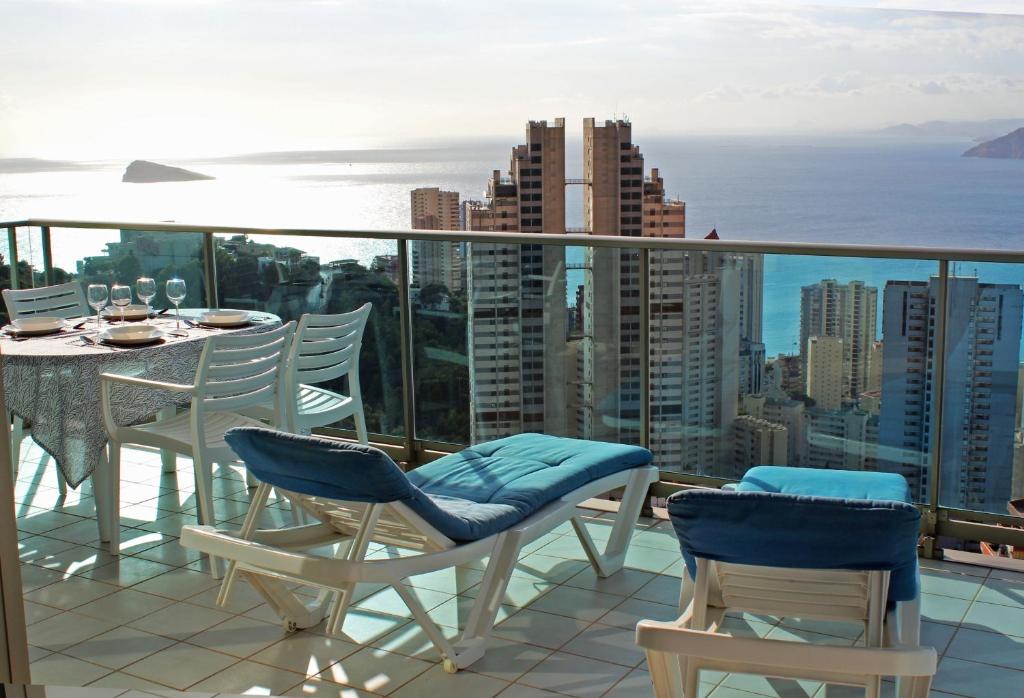balcón con mesa, sillas y vistas al océano en Stunning sea views from a 2-bedroom apartment on the 26th floor, en Benidorm