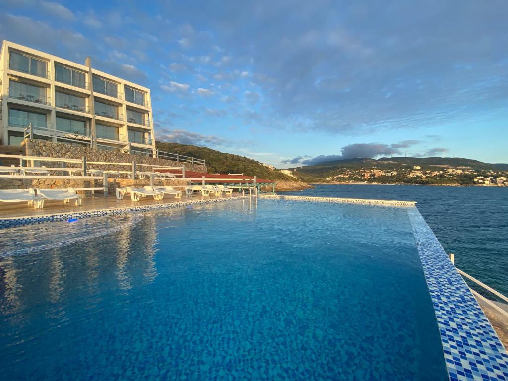 a swimming pool in front of a hotel at Apartments Komina in Utjeha