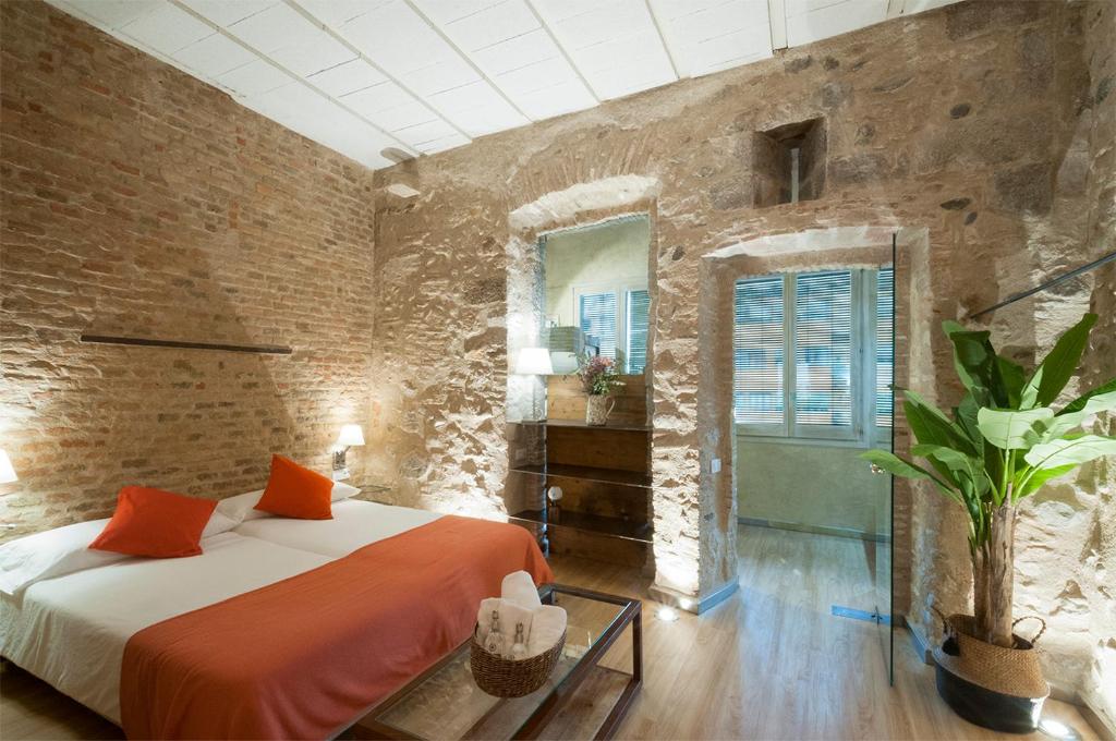 ジローナにあるOnyar apartments Rambla de la llibertat 27のレンガの壁、ベッド2台が備わるベッドルーム1室が備わります。