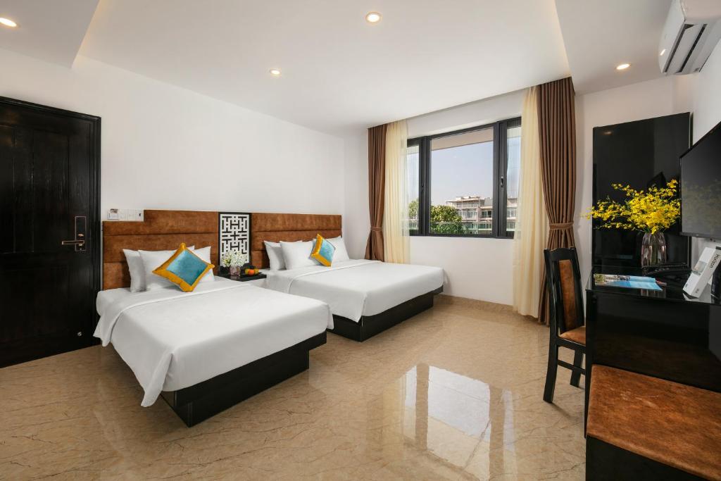 Habitación de hotel con 2 camas y TV en Tuan Chau Kingly Villa, en Ha Long