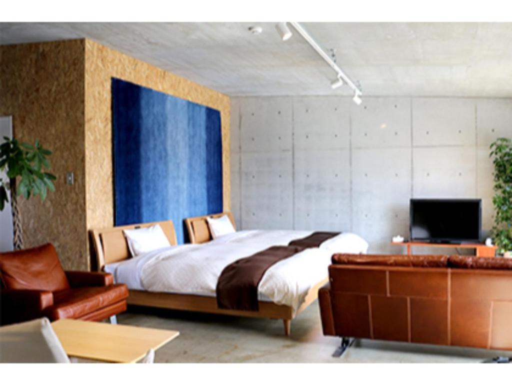 AkaishiにあるOGAL INN - Vacation STAY 01879vのベッドルーム(ベッド1台、ソファ、テレビ付)