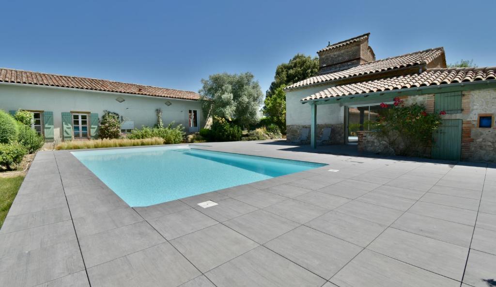 a swimming pool in the yard of a house at Le pigeonnier de La Mouline in Viterbe