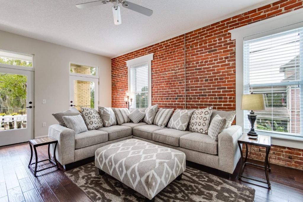 a living room with a couch and a brick wall at JBH 115 W 2nd Apt #3 in Jacksonville