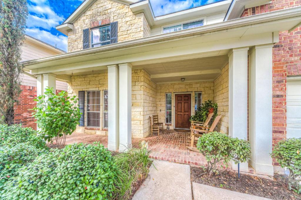a brick house with a front porch with a wooden door at Cozy home near Houston Medical Center, NRG Stadium and Galleria in Manvel