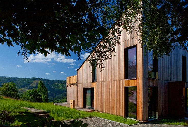 una casa con paneles de madera en el lateral en Apartamenty Malinka en Wisła