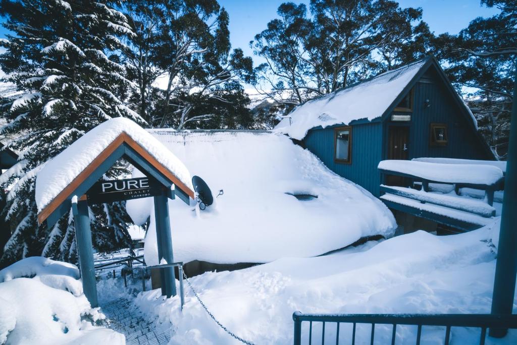 a snow covered cabin in the snow at Pure Chalet Thredbo in Thredbo