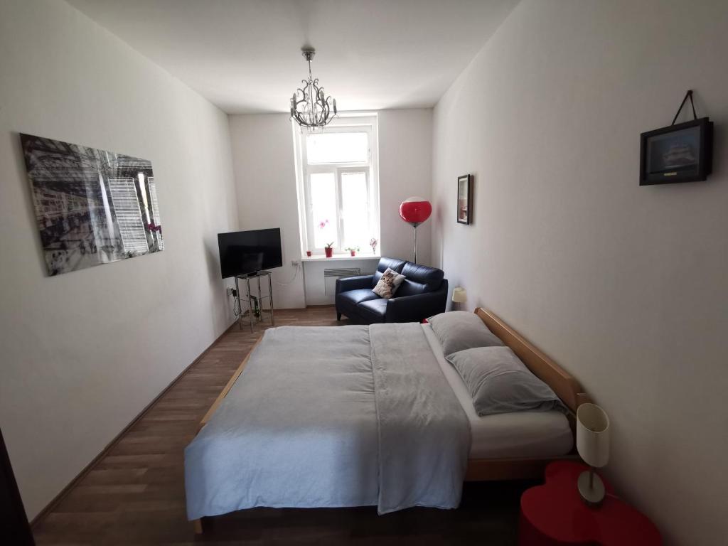 a bedroom with a bed and a couch and a window at Apartma MB-Center in Maribor