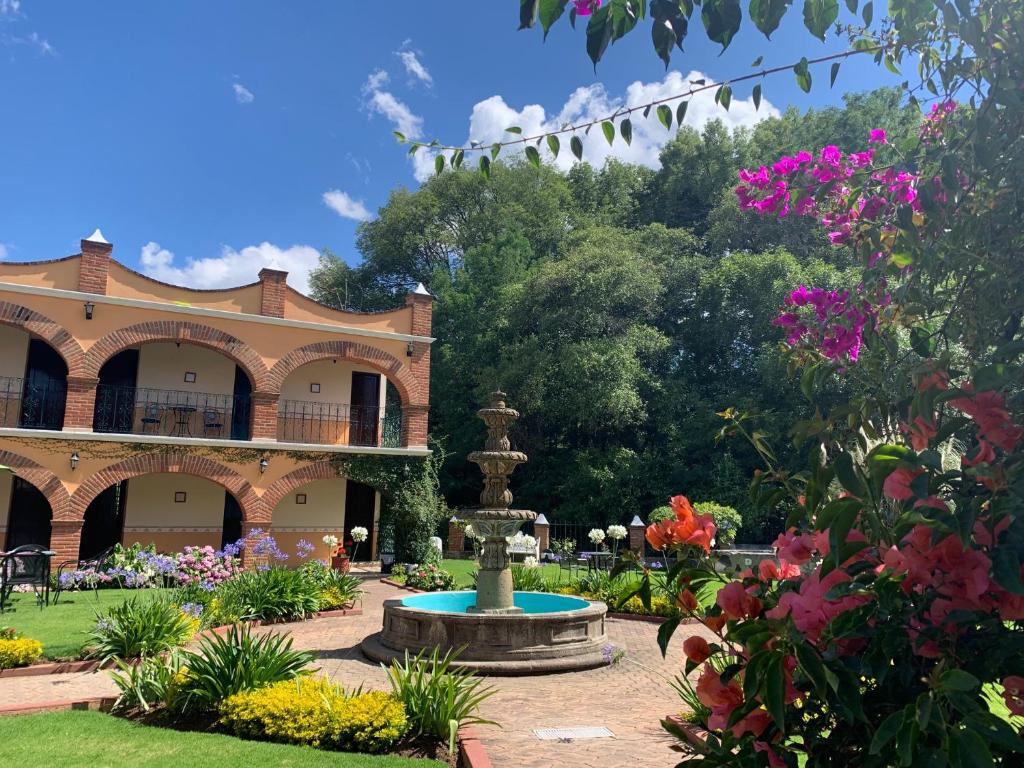 un jardín con una fuente frente a un edificio en Hotel Real de Huasca, en Huasca de Ocampo