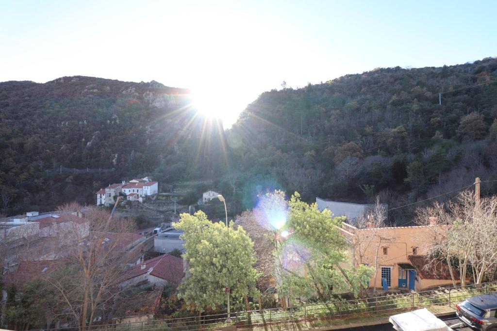 a city with the sun shining on a mountain at Locations appartements standing Amélie-les-bains in Amélie-les-Bains-Palalda